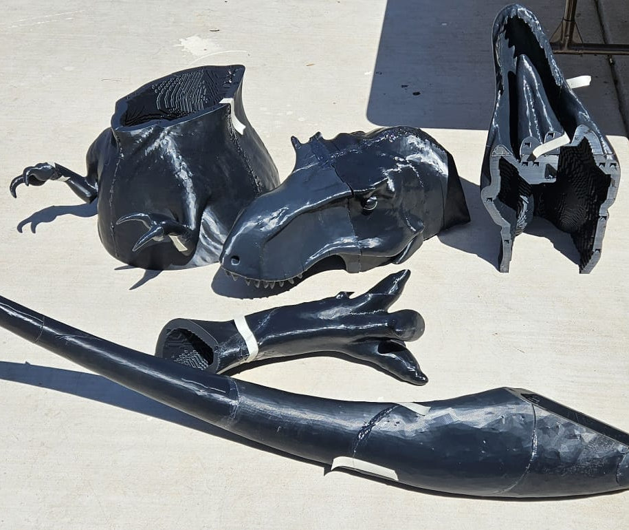 Black T. rex parts laid on concrete, hollow interior visible
